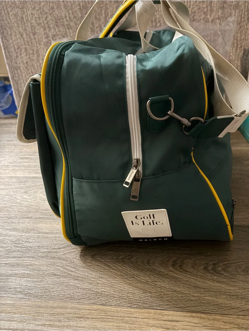 MALBON Green and gold duffel/weekender travel bag.